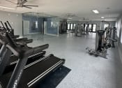 Thumbnail 13 of 31 - a gym with treadmills and other exercise equipment in a building